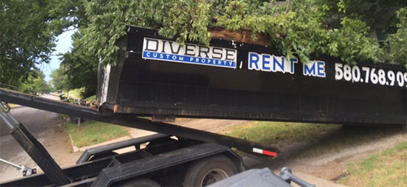 roll off dumpster being collected